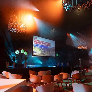 von LED Strahlern beleuchtetes Forum mit Bühne und Leinwand